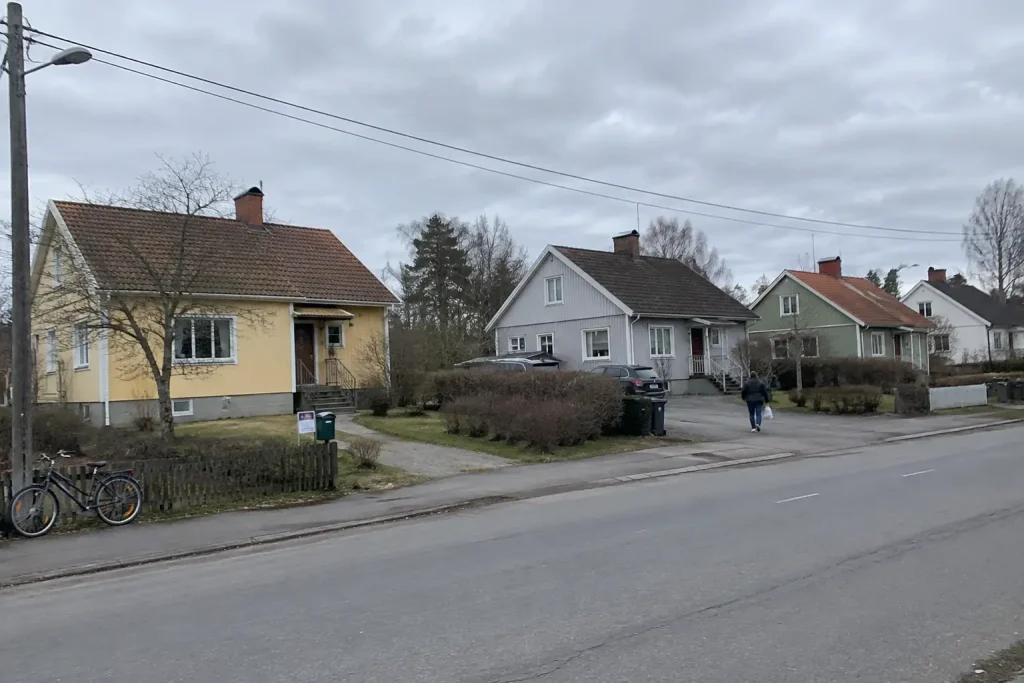 Villagata i förort med uthyrningsskylt vid en brevlåda, tema för Hyra ut villa: från en lånad etta till ett bestånd
